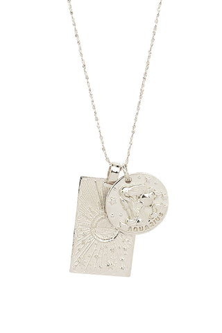 close-up-front-view-of-spell-s-aquarius-stargazer-zodiac-necklace-charms-one-charm-is-of-a-rectangular-shape-and-features-a-sun-with-stars-while-the-other-charm-is-circular-and-features-the-zodiac-label-and-icon